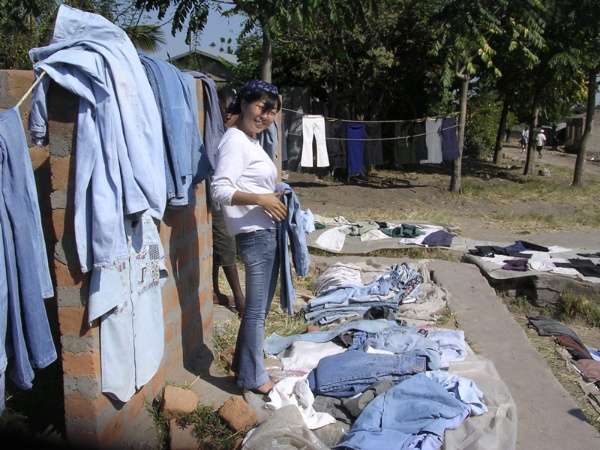 タンザニア・ムワンザ市の露店でジーンズを売る小川さやかさん。調査対象のマチンガの社会に自ら入り、長期間生活を共にしながら観察した（2004年、提供：小川さん）