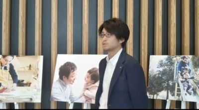 男性育休を1カ月程度取得した国家公務員が、家庭での育児・家事に励む一コマを紹介した「霞が関のパパたち写真展」をPRしている永田さん
