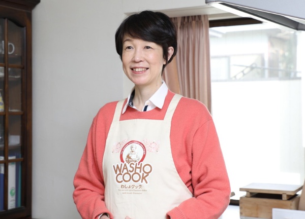 エプロンに描かれたロゴのイラストは義母・孝子さんがモデル。「母の料理とともにロゴが世界中に広がるのが夢なんです」と語るわしょクック代表取締役、富永紀子さん
