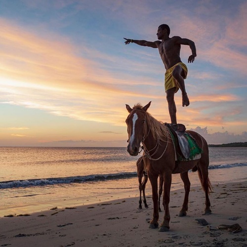 フィジーではビーチで乗馬を教えてもらえる。おちゃらけて馬の上に立つフィジー人