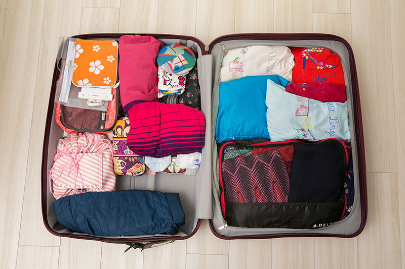 スーツケースのジッパー付きカバーのあるスペース（写真右側）には衣類、カバーなしのスペース（左側）には靴や日用品などを収納。カバーなしのスペースには、出張先へのお土産を入れ、帰りはそこに日本へのお土産を入れます