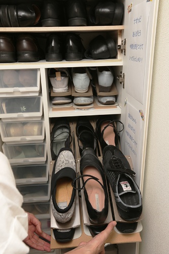 玄関の靴入れは部分的に奥行きが深く、縦に靴が２足分入るという不規則な形。ホームセンターで購入した板に取っ手を付け、その上に靴を並べることで、奥にある靴も取りやすく