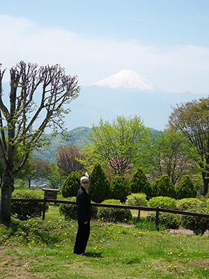 最近、富士山が見渡せる山梨がお気に入りの場所という佐伯チズさん。富士山をバックに記念撮影。でも、目からの紫外線でも日焼けすることがあるので、サングラスは手放しません。