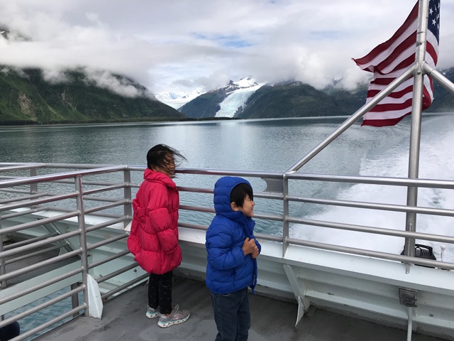 旅行先のアラスカで、クルーズ船から氷河を眺める子どもたち