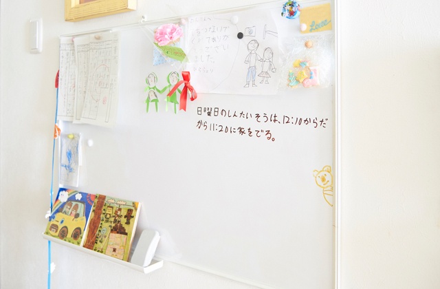対面式キッチンの目の前の壁に掛けている大型のホワイトボード。家族間の伝達事項を書くだけでなく、疑問に思っていることや思い付いたアイデアをメモしたり、作品を展示したりとフル活用している