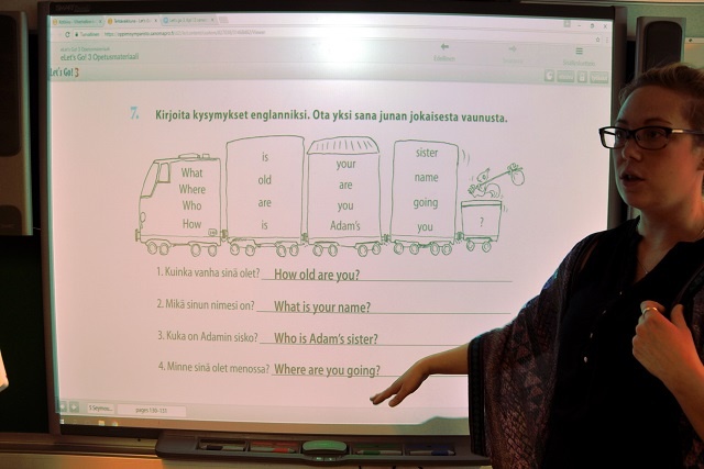 3～6年生に英会話を教えるサッラ・カイトカリさん。タブレットと画面共有したスクリーンで文を作って会話をし合い、チームごとに課題クリアの速さを競う