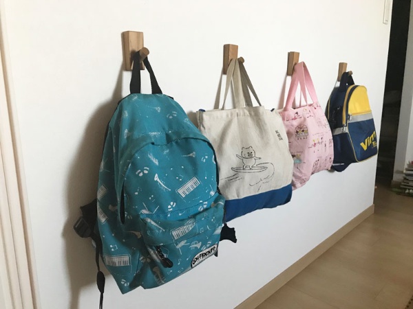 子どもたちの保育園用バッグやリュックは、家に入ってすぐのところにずらっと並べて掛けておく。子どもが自分で掛け外ししやすい高さに「壁に付けられる家具」の「フック」を設置した