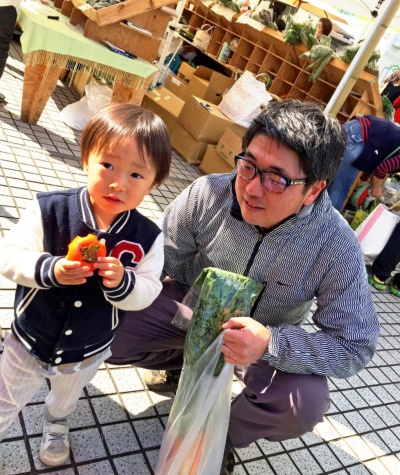 当時2歳の長男が皮付きの柿を渡されて食べている様子。右にいるのが今井農園の今井さん