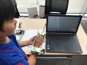小学３年生が作った「会話おたすけ音声ロボット」。ケガや病気で話したり書いたりすることが難しい人に便利な会話支援ツール。レゴでつくったグローブを手にはめ、パソコン画面のひらがな表をクリックするとその文字を読み上げてくれる（写真提供／石戸奈々子さん）