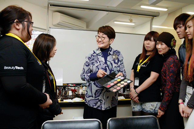 美・ファイン研究所で、自ら開発した化粧品について、海外留学生に説明する小林さん