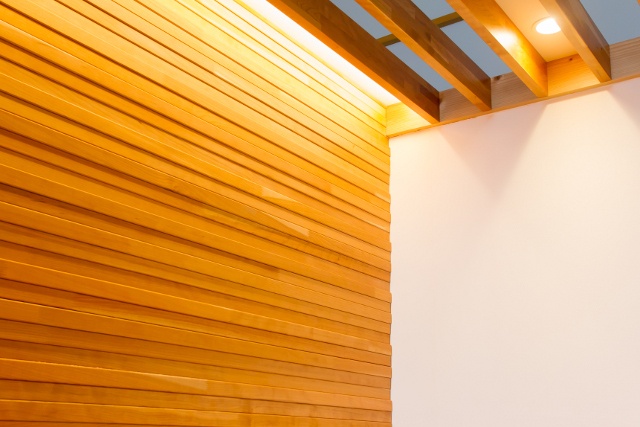 壁に木を使うとき、凹凸のあるデザインの木質壁材を使うと壁に陰影ができ、照明が適度に柔らかく感じられて目に優しい空間になる
